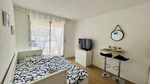 um quarto com uma cama, uma televisão e um espelho em Les Appartements De Lina By LG Immo - Self Check-In - em La Grande-Motte
