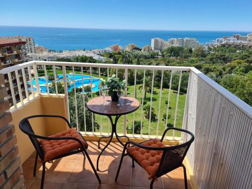 a balcony with a table and two chairs and the ocean at ÁGUiLA WONDERFUL AT HOME in Benalmádena