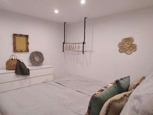 ein weißes Schlafzimmer mit einem Bett und einem Spiegel in der Unterkunft Frankenholzer Ferienwohnung in Bexbach