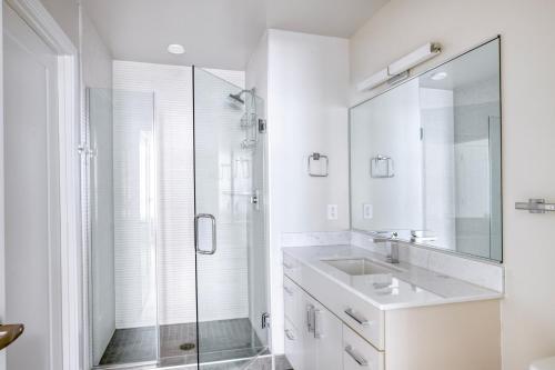 La salle de bains blanche est pourvue d'un lavabo et d'une douche. dans l'établissement NoMa 1br w wd concierge gym nr Metro WDC-647, à Washington