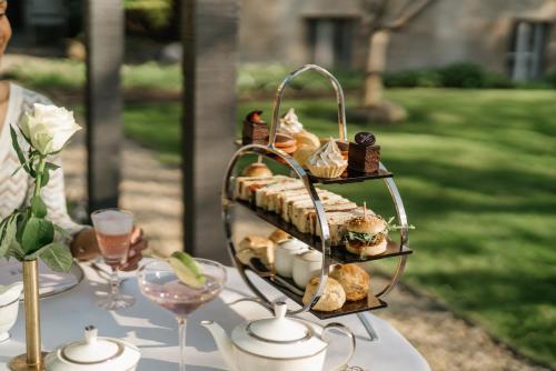 a plate of sandwiches and pastries on a table at The Roseate Villa Bath in Bath