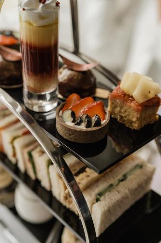 a tray of different types of pastries and a drink at The Roseate Villa Bath in Bath