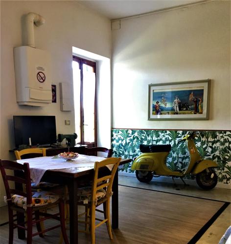 a dining room with a table and a yellow scooter at Welcome in Toscana in Polcanto