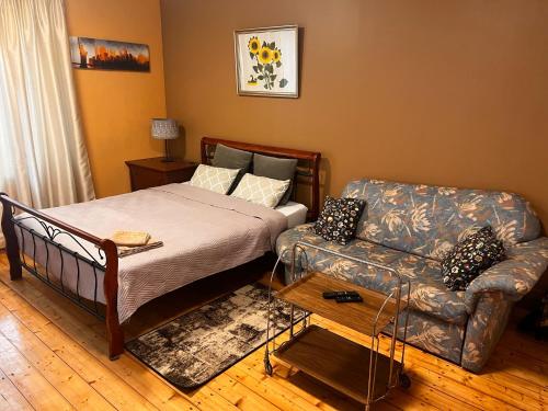 um quarto com uma cama e um sofá em Unique Mailo cottage em Riga