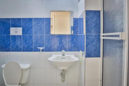 baño de azulejos azules con lavabo y aseo en Hotel Stil Cartagena, en Cartagena de Indias