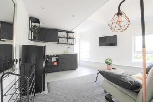 een woonkamer met zwarte kasten en een bank bij StayRight Cosy Mezzanine Flat in Vibrant Area - Walking Distance to Central Cardiff in Cardiff