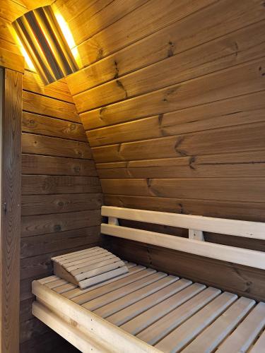 a sauna with wooden walls and a bed in it at Vidusgrīvas in Nidden