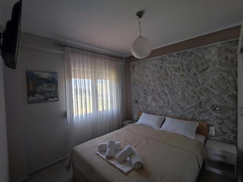 a bedroom with a bed with two towels on it at A & F Apartments - Ari's house in Kalivia Poligirou