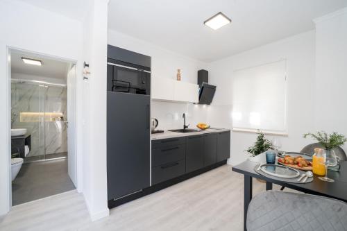 a kitchen with black cabinets and a table in a room at Royal Rei Suite in Umag