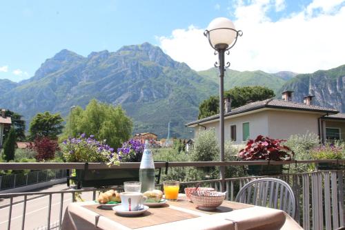 una mesa en un balcón con vistas a las montañas en B&B Casa Wanda since 1999, en Riva del Garda
