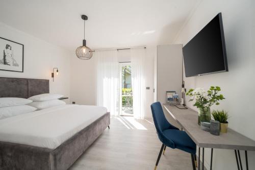 een slaapkamer met een bed, een bureau en een televisie bij Royal Rei Suite in Umag