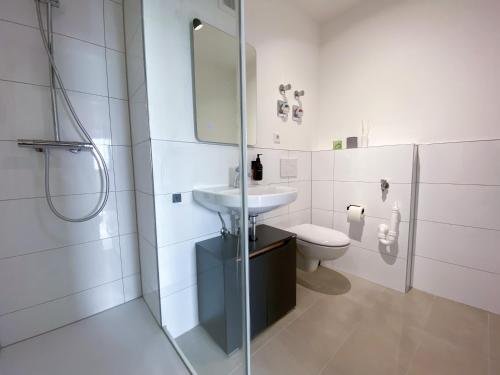 ein weißes Bad mit einem Waschbecken und einem WC in der Unterkunft Schöne Wohnung mit Rheinblick/Düsseldorf/Neuss/Messe in Neuss