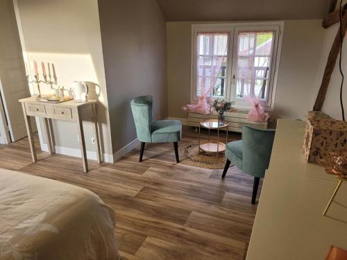 a bedroom with a bed and a desk and chairs at Les Gites de l'Herperie in Blicourt