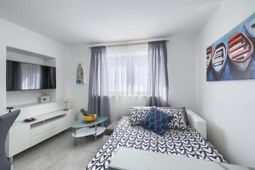 a bedroom with a bed and a table and a window at Studio apartman Luka in Pomer