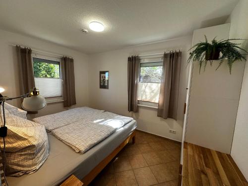 a bedroom with a bed and two windows at Klättes Ferienwohnung mit Garten in Zagelsdorf