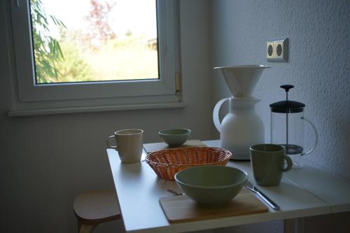 a table with four bowls and a vase on it at Klättes Ferienwohnung mit Garten in Zagelsdorf