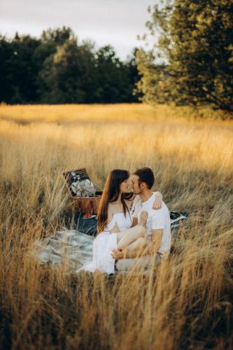 a couple kissing in a field of tall grass at Wild House Donovaly in Donovaly