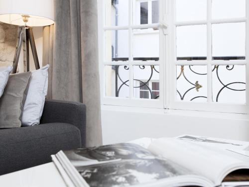 ein Wohnzimmer mit einer Couch und einem Fenster in der Unterkunft LivinParis - Luxury 2 Bedrooms Le Marais I in Paris