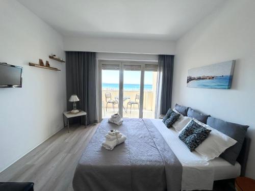 a bedroom with a bed and a view of the ocean at Sunset Erice Beach in Trapani