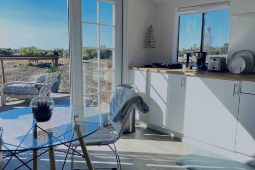 a kitchen with a glass table and chairs and a counter at 30 PCT OFF! Malibu Serene Cabin, Ocean View, Beach in Malibu