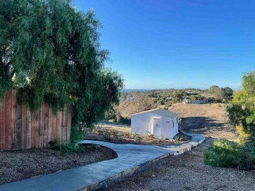 a small white building on a sidewalk next to a fence at 30 PCT OFF! Malibu Serene Cabin, Ocean View, Beach in Malibu
