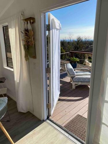 an open door to a deck with a chair at 30 PCT OFF! Malibu Serene Cabin, Ocean View, Beach in Malibu