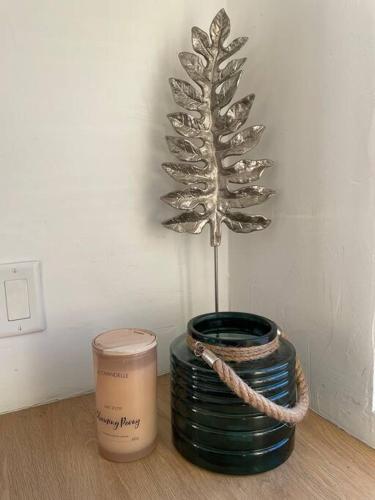 a plant in a vase on a table with a candle at 30 PCT OFF! Malibu Serene Cabin, Ocean View, Beach in Malibu