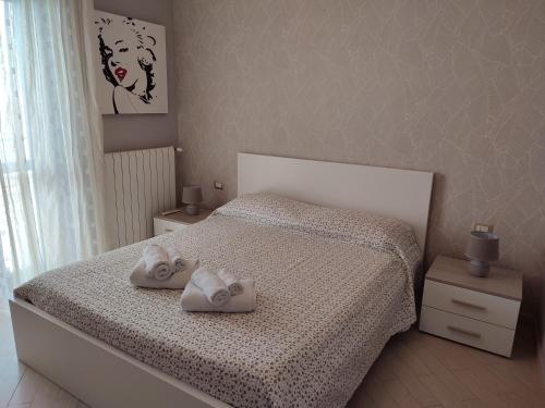 a bedroom with a bed with two towels on it at Casa Twins in Bari