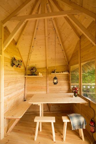 a wooden room with a table and benches in a cabin at Wild House Donovaly in Donovaly