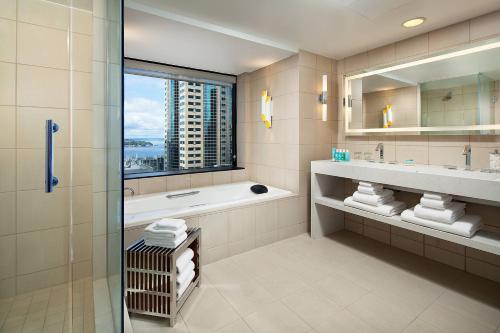 a bathroom with a tub and a sink and a shower at W Seattle in Seattle