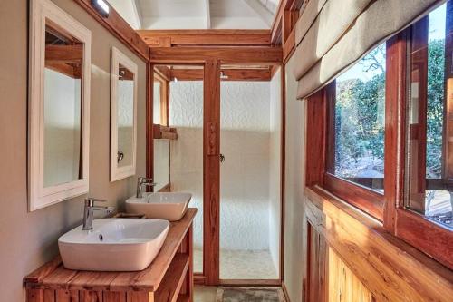 a bathroom with two sinks and a large window at Aloha 10 I 4Bed Villa with Stunning Sea View Pool in Ponta Mamoli
