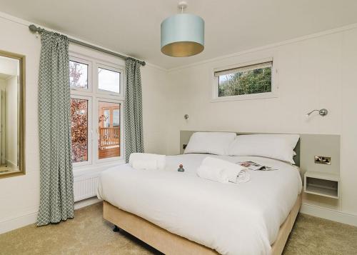 a bedroom with a large white bed and a window at Canterbury Reach Lodge Retreat in Petham