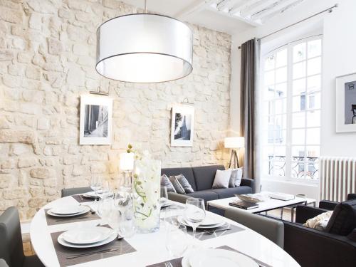 une salle à manger avec une table et des chaises dans l'établissement LivinParis - Luxury 2 Bedrooms Le Marais I, à Paris