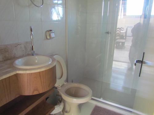 a bathroom with a sink and a toilet and a shower at Apartamento Das Flores in Gramado