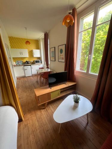 ein Wohnzimmer mit einem Sofa und einem Tisch in der Unterkunft L’appartement Le Mer’Ville in Saint-Nazaire