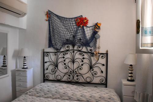 un letto con testiera metallica in una camera da letto di appartamento Romi a Porto Cervo