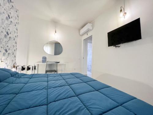 a bedroom with a blue bed and a tv at casa D’ Amare in Marettimo