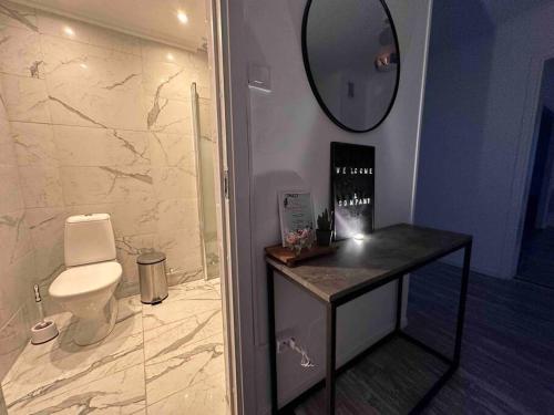 uma casa de banho com um WC e um espelho na parede em Modernt & rymligt sommarhus på landet- Bubbelpool em Eskilstuna