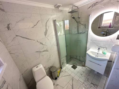 a bathroom with a sink and a toilet and a mirror at Modernt & rymligt sommarhus på landet- Bubbelpool in Eskilstuna