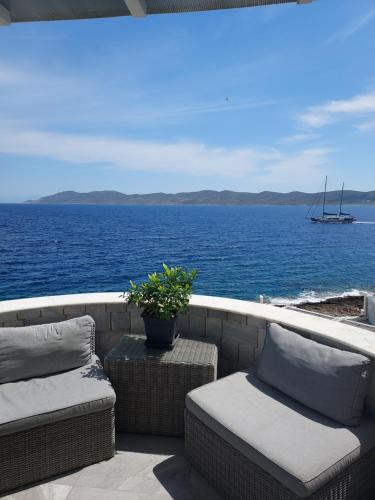 a balcony with a view of the ocean and a boat at En plo villa Sounio in Sounio