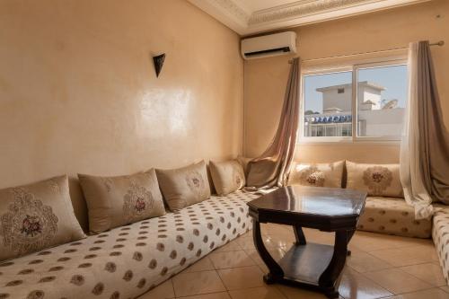- un salon avec un canapé et une table dans l'établissement Agadir Beach Appartment, à Agadir