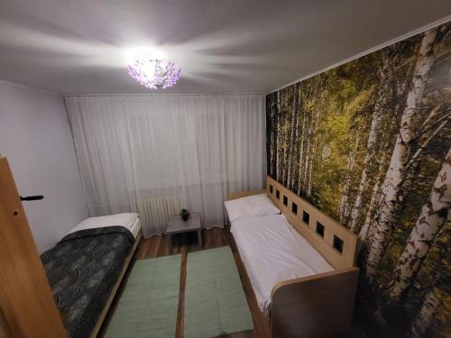 a small room with two beds and a chandelier at Apartmán George in Bratislava