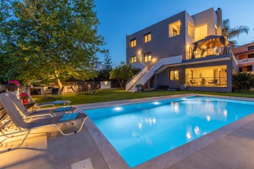 a villa with a swimming pool and a house at Crystal Waves lux villa-Homeleader in Chania Town