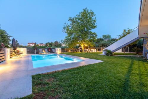a backyard with a swimming pool and a grass yard at Crystal Waves lux villa-Homeleader in Chania Town