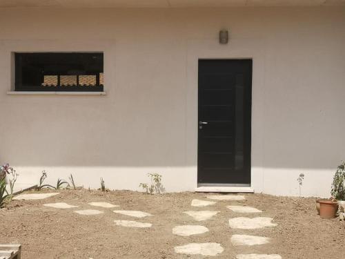 ein weißes Gebäude mit einer schwarzen Tür und einem Fenster in der Unterkunft Chez Ramses in Marseille