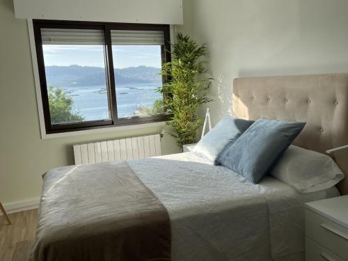 - une chambre avec un grand lit et une grande fenêtre dans l'établissement Mirador Puerto Náutico, à Moaña