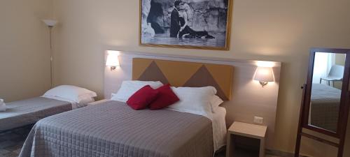 una camera d'albergo con letto e cuscini rossi di Vatican View Rooms a Roma
