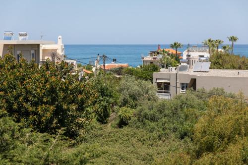 a building with the ocean in the background at Crystal Waves lux villa-Homeleader in Chania Town