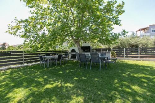 a table and chairs under a tree in a yard at Crystal Waves lux villa-Homeleader in Chania Town