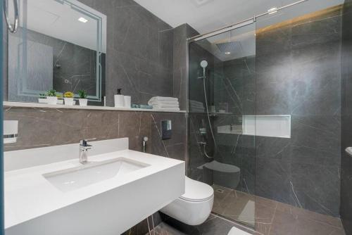 a bathroom with a sink and a toilet and a shower at Modern one-bedroom in Arjan - Dubaï in Dubai